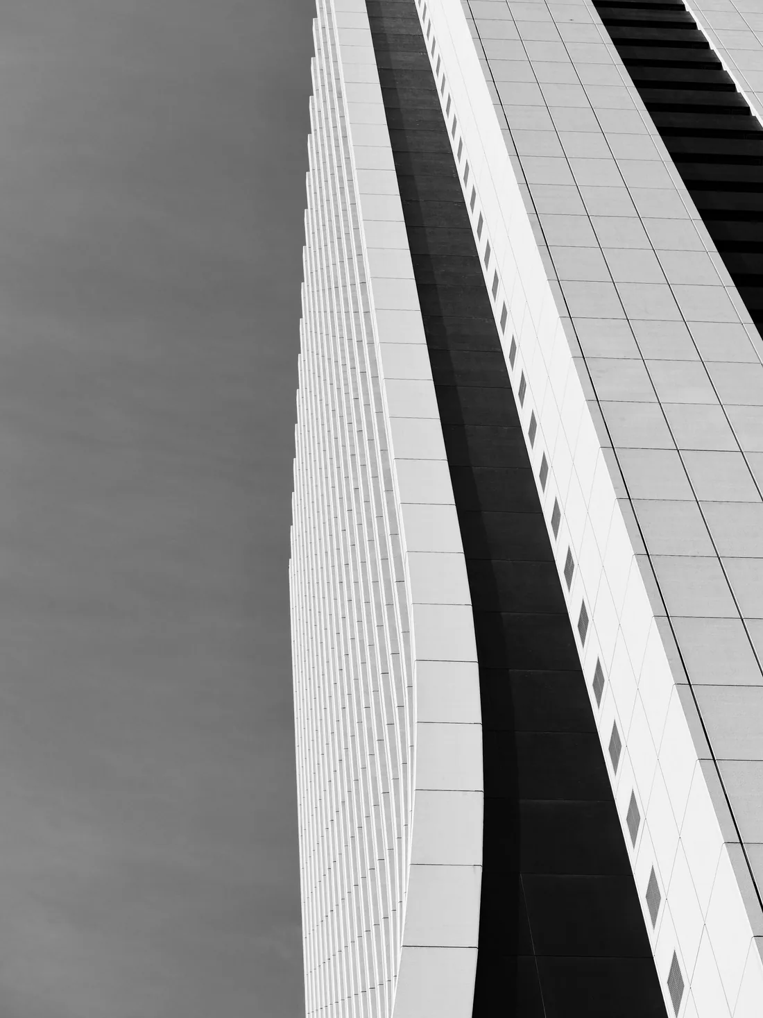 Low-angle black-and-white view of a geometric modern building.